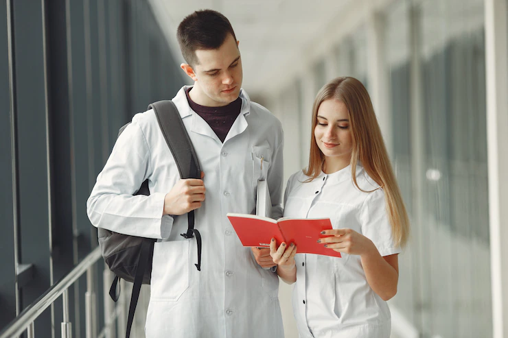 Студенты-медики читают книгу в коридоре вуза